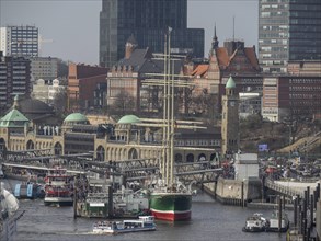Close-up of a harbour with a sailing ship and historical next to modern buildings, many ships in a