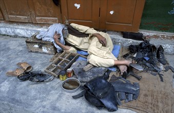Sleeping shoe mender, Pakistan, Asia
