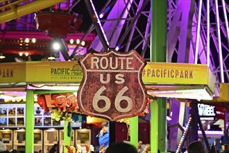 Route 66 sign in front of the Ferris wheel on the pier in Santa Monica, Californi