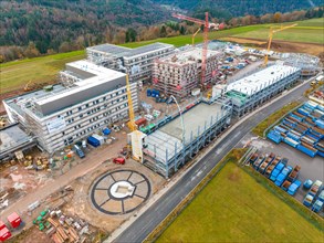 Spacious construction site in rural surroundings with several buildings under construction, high