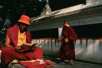Tibetan buddhist monks near the Swayambhunath stupa, Kathmandu valley, Nepal. Tibetan monk reading