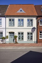 Residential building with pointed roof against a deep blue sky in Toenning, Nordfriesland district,