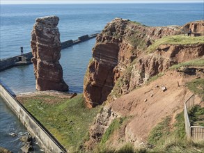 A striking rock formation on the coast, surrounded by the ocean and a clear sky, Heligoland,