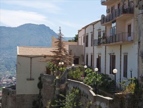 Village with houses on a hill, balconies and mountain landscape in the background, palermo in