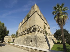 Old fortress wall with trees and green area under the blue sky on a sunny day, The city of Bari on