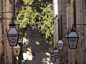 Old town street with hanging lanterns and shop signs, the old town of Dubrovnik with historic