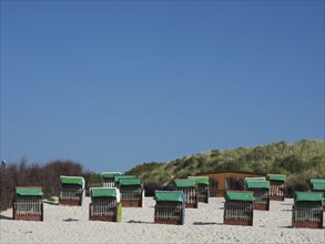 Beach chairs on the sand in front of dunes and blue sky, Heligoland, Germany, Europe