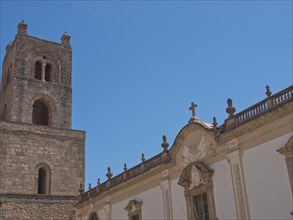 A historic church building with a large tower under a bright blue sky, palermo in sicily with an