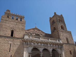 Historic church facade with towers and stone architecture under a clear blue sky, palermo in sicily