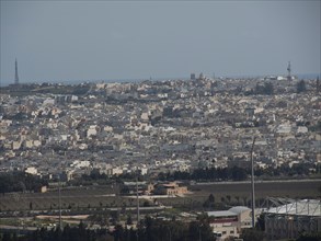 City view with many white and grey houses, sea in the background, urban ambience, the town of mdina