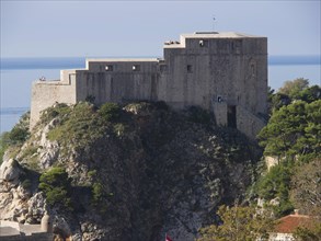An old fortress on a cliff with the sea in the background, historic atmosphere, the old town of
