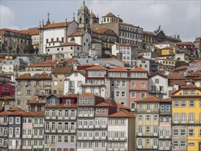 Colourful buildings and a church in a lively old town with steep streets and red roofs, Colourful