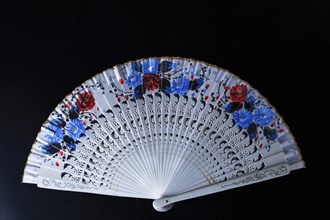 Colorful typical spanish handmade fan isolated on black background with copy space