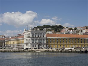 Historic buildings on a riverside under a blue sky with white clouds in Lisbon, Lisbon, Portugal,