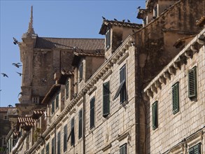 Stone buildings with battlements and wooden shutters in a historic old town, the old town of