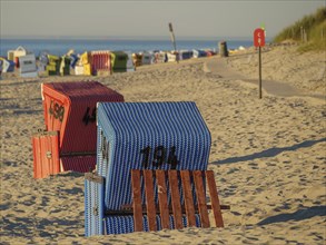 Close up of some blue and red beach chairs on a quiet beach, evening mood on the beach with a