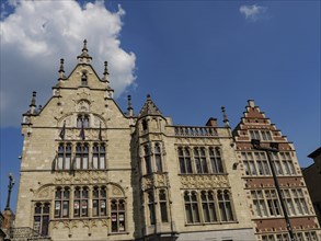 Ornamental historic facades in gothic style against a bright blue sky in an urban environment,