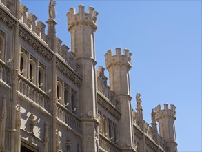 Historic building with stone, ornate towers and a clear blue sky in the background, palma de