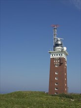 A red lighthouse stands in front of a clear blue sky, Heligoland, Germany, Europe