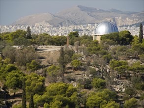 Observatory with a dome surrounded by trees, with a city and mountains in the background, Ancient