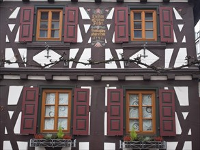 Detail of a half-timbered house with red shutters and decorative flowers on the window, kandel,