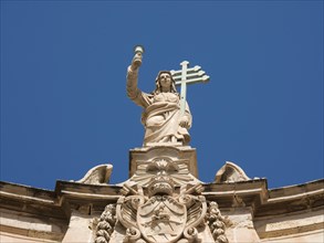 A statue of Justizia on a church under a blue sky, Valetta, Malta, Europe