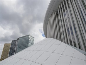 White dome and modern glass buildings in Luxembourg under a cloudy sky, modern buildings with trees
