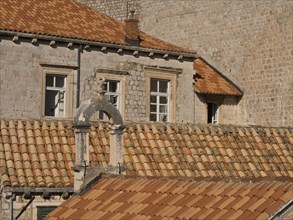 Historic buildings with red tiled roofs and many windows, the old town of Dubrovnik with historic
