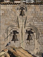 Three bells on an old stone wall, detail from a medieval town, the old town of Dubrovnik with