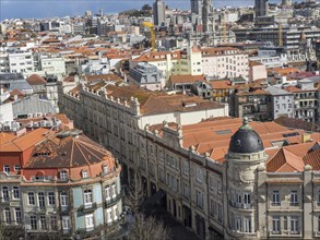 Panoramic view of a city with many red roofs, historic and modern buildings in the city centre, old
