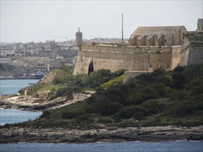 Historic fortress on a hill with sea and city in the background, Valetta, Malta, Europe