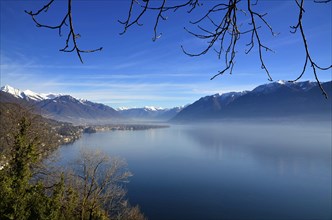 Panoramic View over Lake Maggiore with Snowcapped Mountain in a Misty Morning and in a Sunny Day in