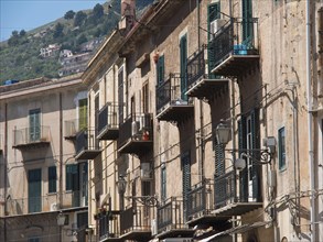 Residential houses with numerous balconies and shutters, against a background of hills, palermo in
