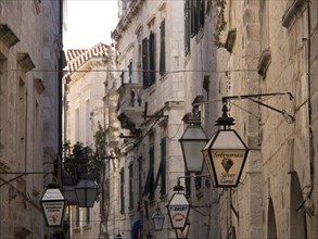 Narrow alley with historic houses, lanterns and signs in an old town atmosphere, the old town of