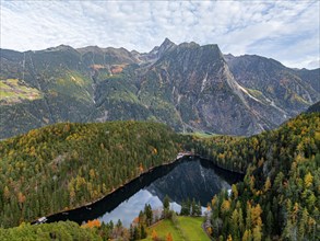 Aerial view, mountain peaks of the Oetztal Alps reflected in Lake Piburger See, in autumn, near