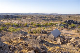 Hobatere Roadside Campsite, Barren landscape with rocky hills and acacia trees, African savannah in