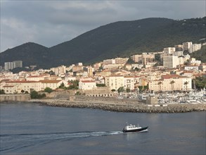 Coastal town with harbour and many buildings at the foot of wooded hills, Corsica, ajaccio, France,