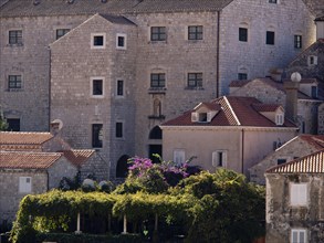 Historic stone buildings with green plants and beautiful gardens that create a peaceful medieval