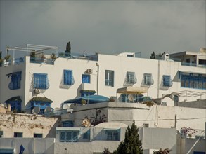 White house with blue window shutter, typical Mediterranean, bright sun and clear sky, Tunis in