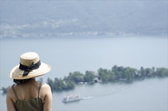 Woman with a Straw Hat Enjoy the Panoramic View over Brissago Islands and Passenger Ship on Lake