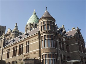 Historic Gothic church with imposing towers and multiple windows under a clear blue sky, Haarlem,