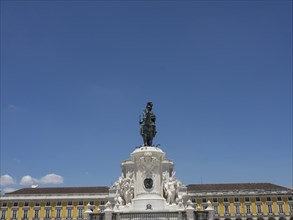 A statue on a square in front of a yellow building under a clear blue sky, Lisbon, Portugal, Europe