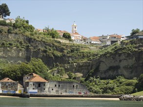 Village on a hill with a church and old buildings, surrounded by rocks and a river, Lisbon,