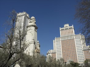 Urban scene with tall buildings and a central monument under a clear sky, Madrid, Spain, Europe
