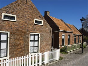 Traditional brick houses and white-painted window frames under a blue sky, Enkhuizen, Nirderlande