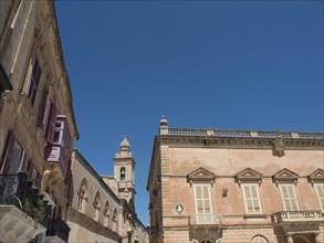 Historic buildings and a church tower under a clear blue sky, the town of mdina on the island of