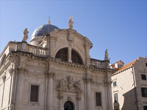 Mighty cathedral with statues and detailed facade under a clear sky, the old town of Dubrovnik with