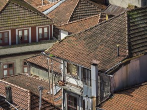 Close-up of old buildings with red tiled roofs and balconies giving a weathered, charming