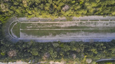 Aerial view of an ancient stadium in ruins, surrounded by dense forest, Archaeological Site, Rhodes