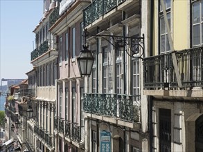 Row of buildings with ornate balconies and traditional street lamps, Lisbon, Portugal, Europe